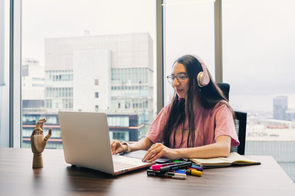 Mahasiswa desain bekerja dengan laptop di ruang kreatif Malang
